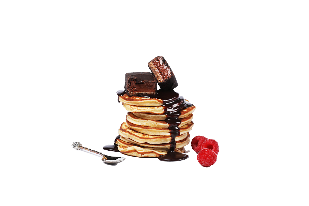 Ein Stapel Pancakes mit Schokoladensauce und einem Schokoladen-Protein Eis-Riegel von Frozen Power dekoriert mit Himbeeren, ideal als proteinreiche Dessert-Option oder Fitness-Snack.