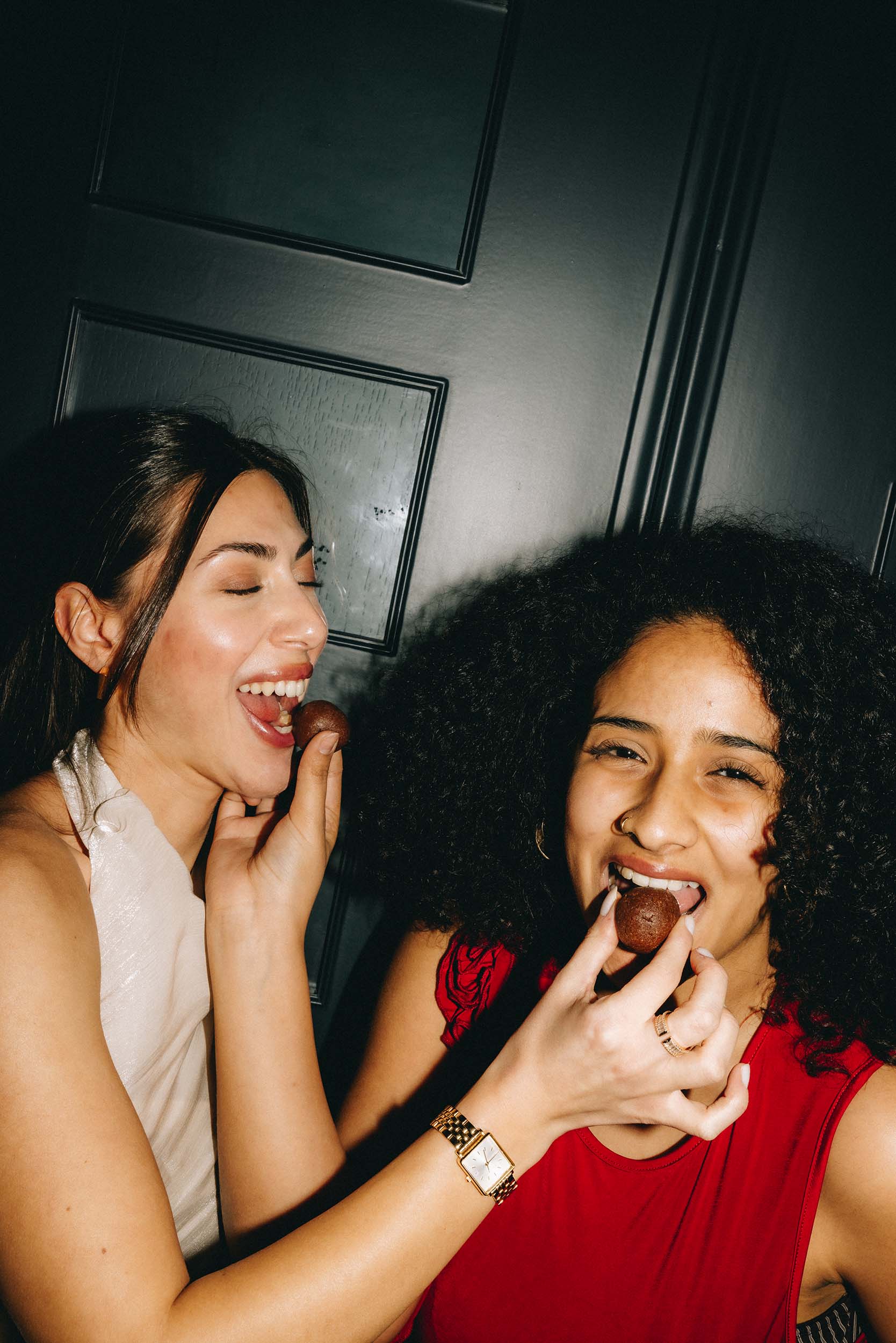 Zwei Frauen teilen sich die veganen Dattel Energy Bällchen in der Sorte Himbeere ohne Zuckerzusatz von Frozen Power